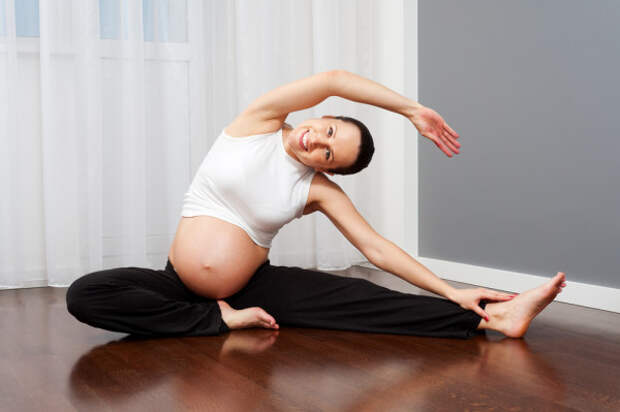 Беременная женщина занимается пилатесом