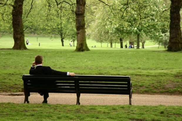 мужчина сидит на скамейке в парке