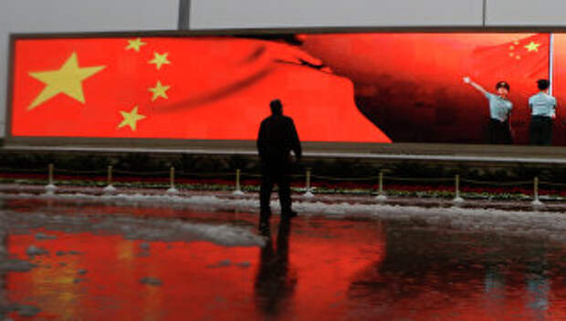 Человек на фоне экрана с флагом Китая, Пекин, архивное фото