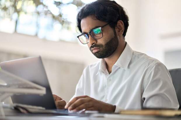 A person with a serious expression at a laptop.
