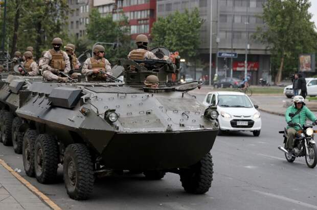 Военные на бронетранспортере патрулируют улицы Сантьяго.