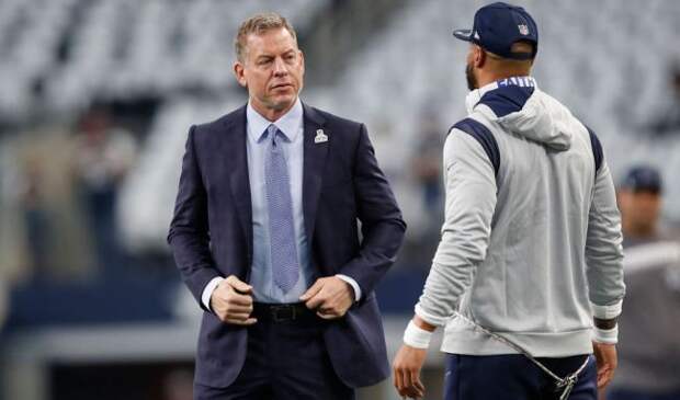 Troy Aikman speaking with dak prescott on the field