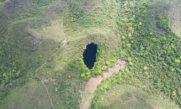 В Китае с самолета увидели провал, уходящий вниз. Его глубина превышает 400 метров, а на дне виден древний лес
