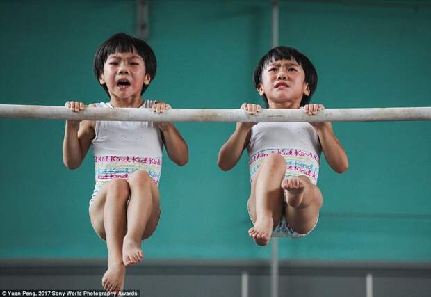 Девочки-близнецы на тренировке по гимнастике в китайской спортивной школе в Цзинине, провинция Шаньдун в мире, дети, жизнь