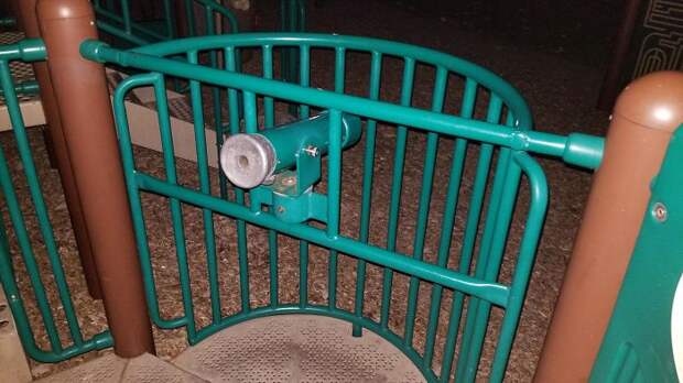 Playground Telescope Aimed At Ground And In Front Of Metal Bars
