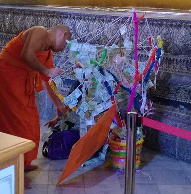 Тайские монахи достают из огромной сумки купюры, чтобы украсить ими «денежное дерево» страны, факты, это интересно
