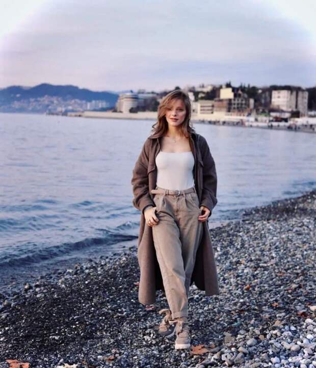 Лиза Арзамасова в белом костюме и накидке на берегу моря
