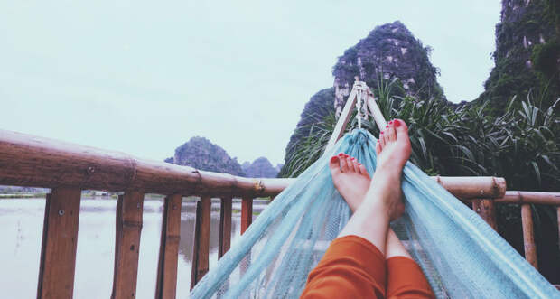 a photo of a person's feet in a hammock looking out over a scenic backdrop