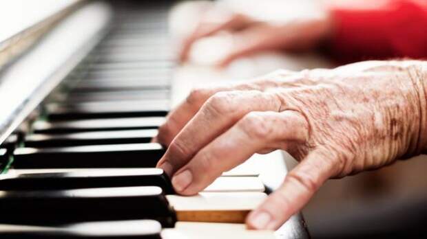 Руки пожилого человека, играющего на рояле