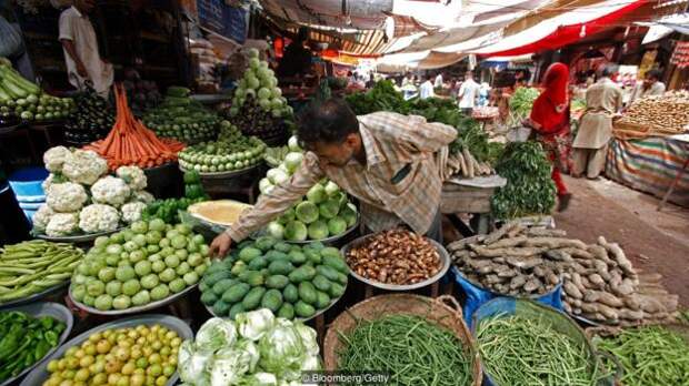 A vendor arranges vegetables at a local market in Karachi, Pakistan