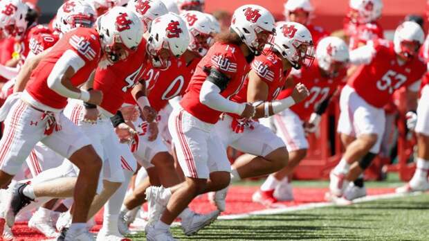 Utah players warm up on the field before a football game.