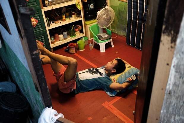 20. Юноша отдыхает в своем скромном жилище бедность, джакарта, железная дорога, индонезия, нищета, репортаж, трущобы