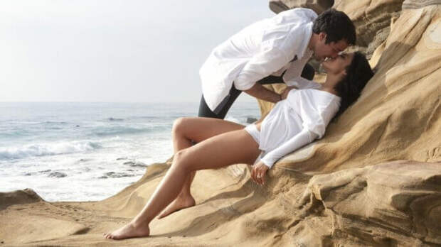 мужчина целует девушку на берегу моря