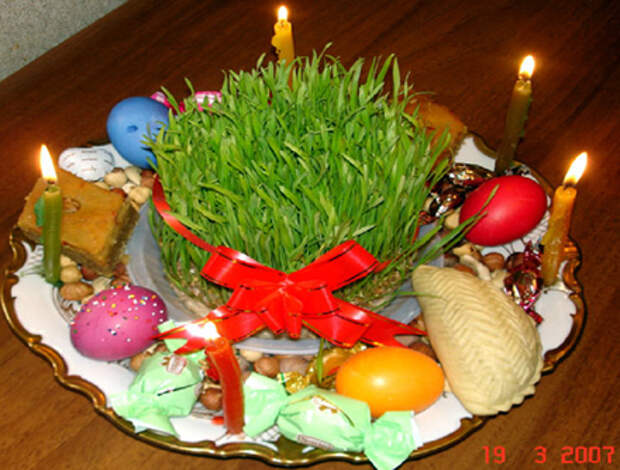 Праздничный стол во время Ноуруза - иранского Нового года, отмечающегося весной. Обязательные атрибуты стола - крашенные яйца, вареники с сыром, свечи, а посредине - миска с проросшим зерном