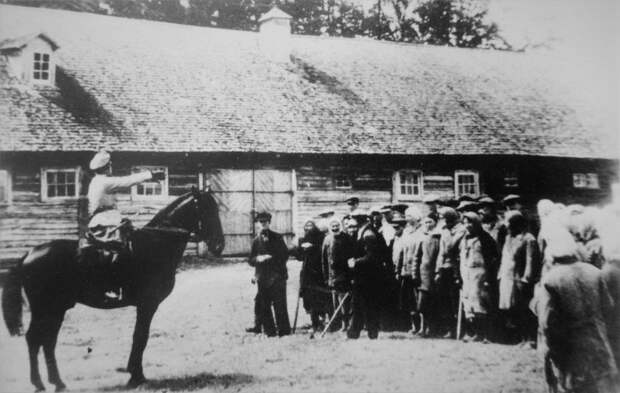 Немецкий чиновник даёт указания жителям оккупированной советской деревни.