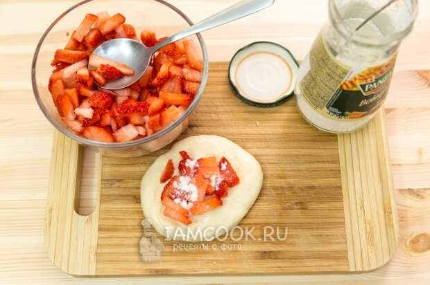 Положить на тесто клубнику