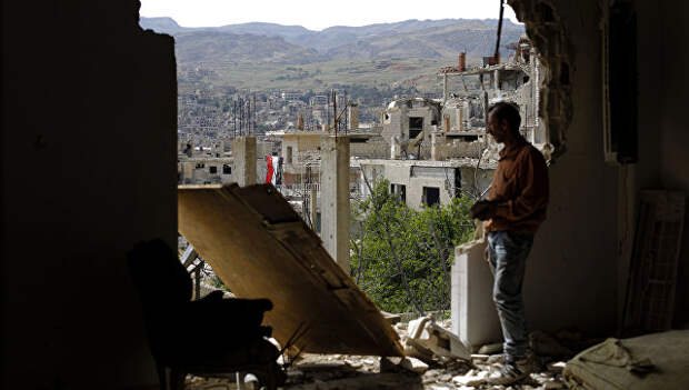 Мужчина смотрит на руины в окрестностях Дамаска после авиаударов коалиции во главе с США по позициям ИГИЛ. 18 мая 2017