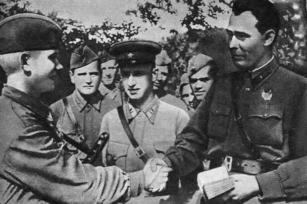 Бригадный комиссар Брежнев (справа) вручает бойцу партбилет. 1942