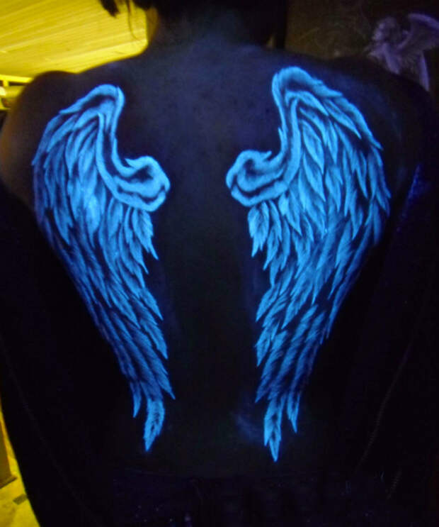 Флуоресцентная татуировка с изображением крыльев.