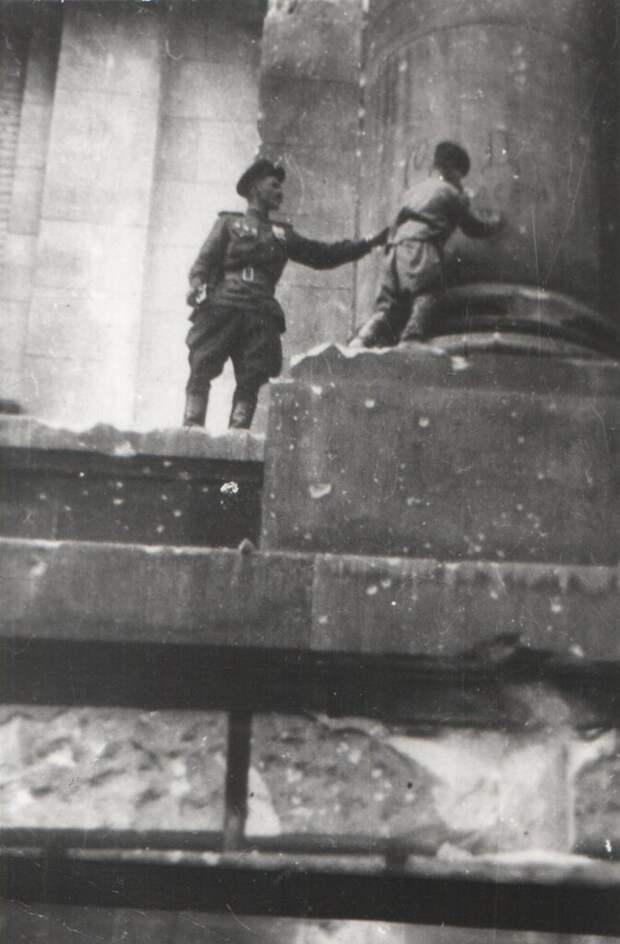 Сын полка Володя Тарновский ставит автограф на колонне Рейхстага. Май 1945
