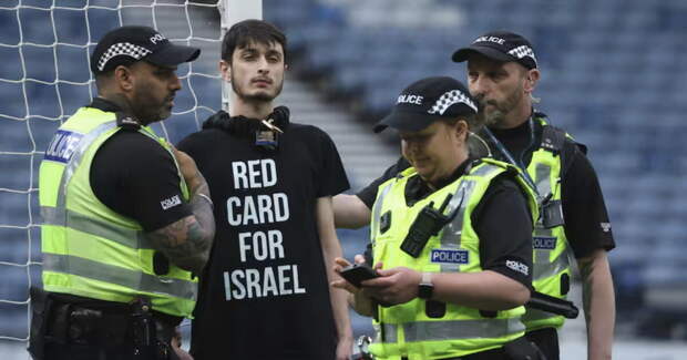 Пропалестинский активист в футболке с текстом «Красная карточка Израилю» приковал себя к воротам перед игрой женской сборной Израиля в Шотландии