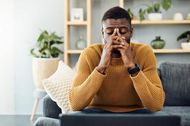 Person sitting on a couch looking worried.