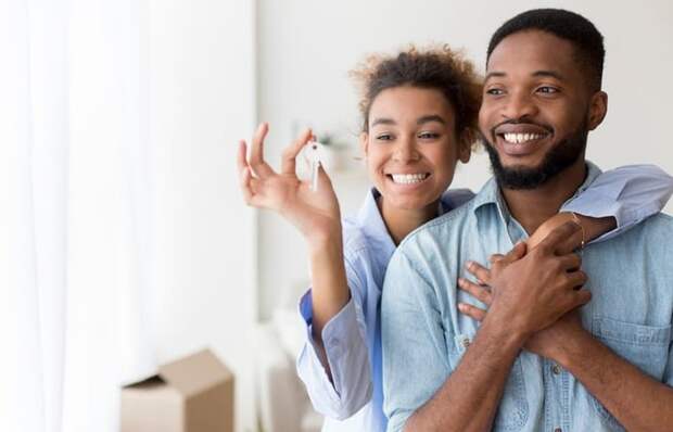 A couple holding up new house keys.