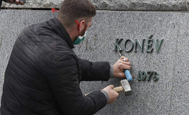 Рабочий снимает табличку с постамента памятника Ивану Коневу в Праге