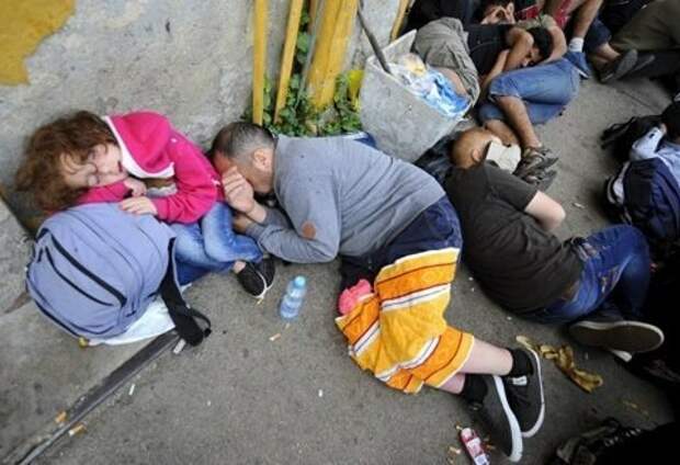 Украинские трудовые мигранты, которых высадили из автобуса, ожидают на границе, когда их пропустят. Фото — 
