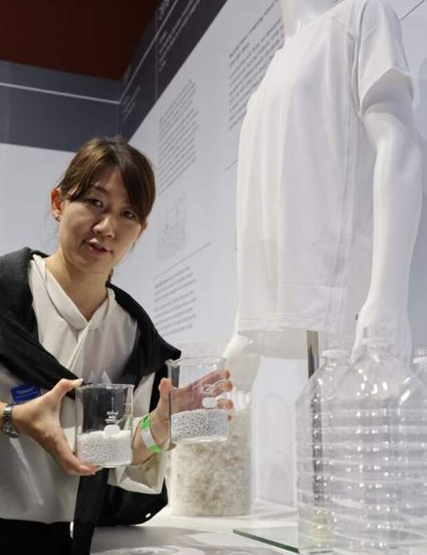1 A woman shows material made from recycled plastic bottles developed by Uniqlo and Toray, and a T-shirt, in London on Monday..JPG 1 A woman shows material made from recycled plastic bottles developed by Uniqlo and Toray, and a T-shirt, in London on Monday..JPG