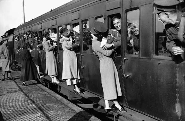Солдаты высовываются из окон вагона, чтобы поцеловать своих близких, 1935 год.