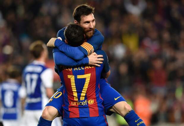 Barcelona's forward Paco Alcacer (bottom) celebrates a goal with Barcelona's Argentinian forward Lionel Messi during the Spanish league football match FC Barcelona vs Real Sociedad at the Camp Nou stadium in Barcelona on April 15,