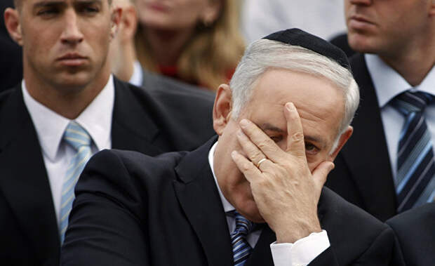 Премьер-министр Израиля Биньямин Нетаньяху закрывает лицо во время церемонии в День памяти жертв Холокоста в мемориальном комплексе Яд Вашем в Иерусалиме