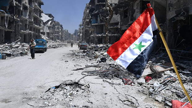 Флаг Сирии в освобожденном лагере палестинских беженцев Ярмук на юге Дамаска. Архивное фото
