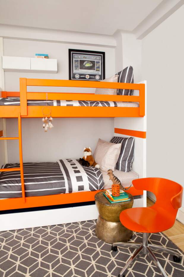 Небольшая спальная комната в светлых тонах с необычной встроенной деревянной конструкцией, которая включает в себя два спальных места.