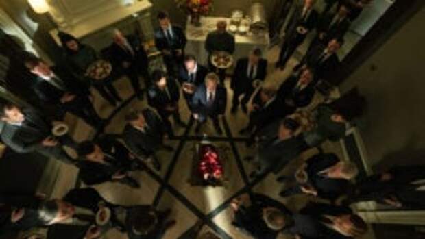 Suited men standing in a pentagram