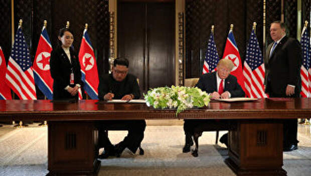 Президент США Дональд Трамп и лидер КНДР Ким Чен Ын Во время подписания документов по итогам встречи в Сингапуре. 12 июня 2018