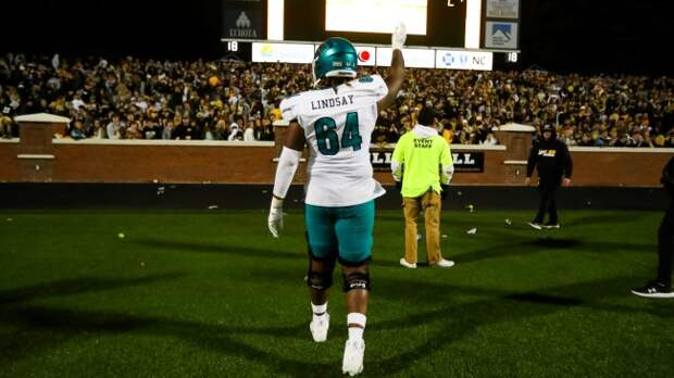 A Coastal Carolina player waves to the crowd at Appalachian State.