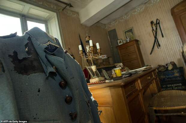 The solider's moth-eaten military jacket hanging next to his desk is pictured above. A sword remains on the wall