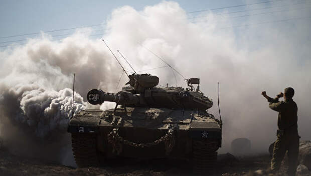 Израильский солдат и танк на Голанских высотах в районе границы с Сирией. Архивное фото