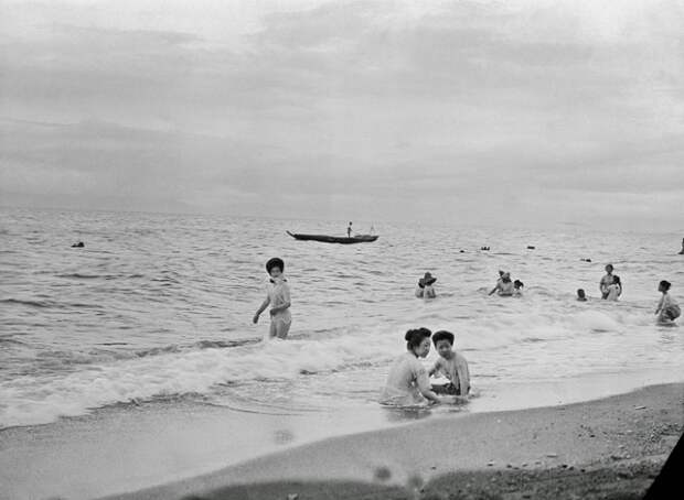 Местные жители купаются на городском пляже. 