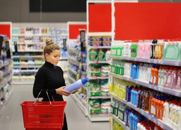 Woman carrying basket while shopping in a big box store.
