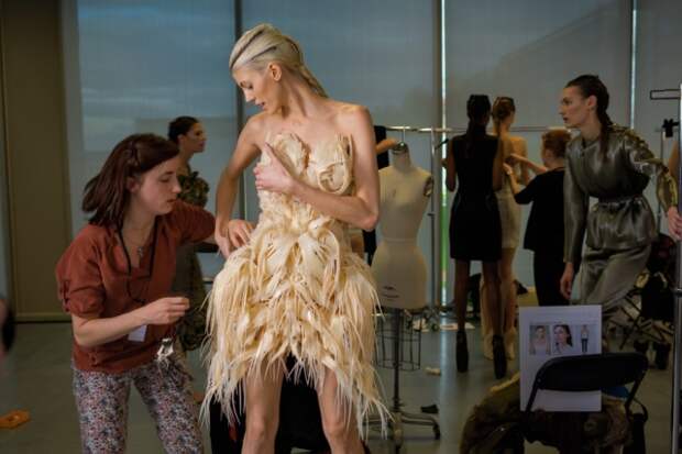 Модель Девон Виндзор готовится к выходу на модном показе Ready to Wear в Париже. Ее платье – плод сотрудничества кутюрье и архитектора, распечатанный на 3D-принтере. Ирис ван Херпен (дизайнер); Джулия Корнер (архитектор). Произведено при участии компании Materialise.