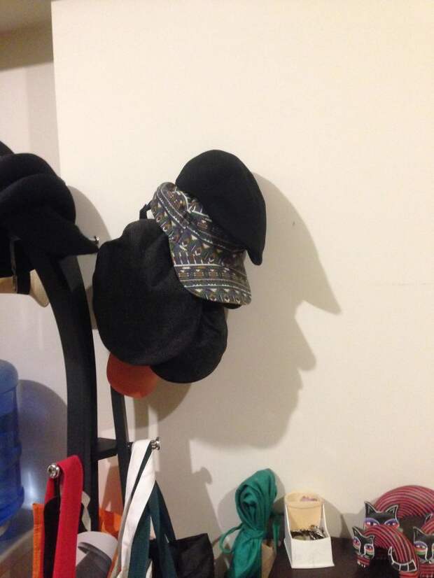 The Hats On This Hatrack Cast A Shadow In The Shape Of A Face
