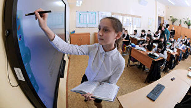 Ученица выполняет задание возле интерактивной доски во время урока в московской школе. Архивное фото
