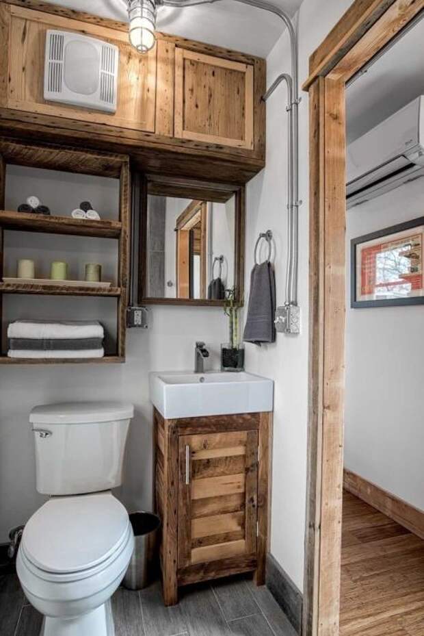 Благодаря деревянным элементам ванная комната смотрится особенно уютно.