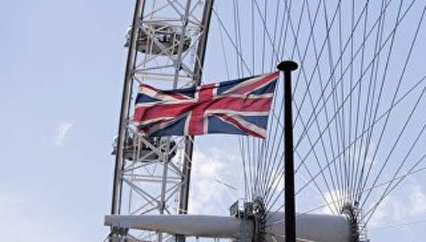 Флаг на фоне аттракциона Лондонский глаз в Лондоне. Архивное фото