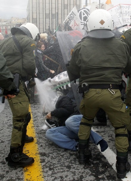 A protester falls on the ground during clashes in central Athens