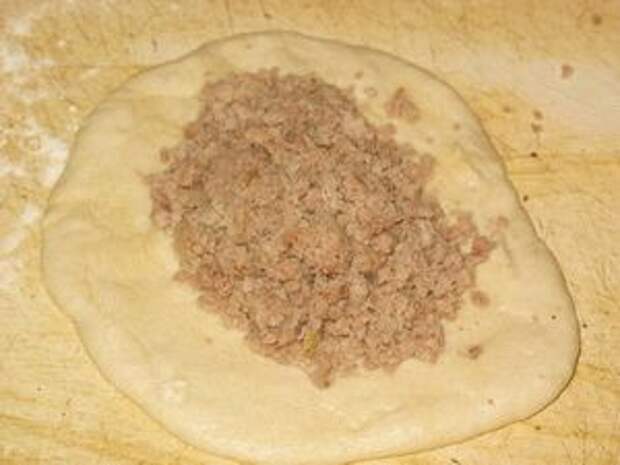 на лепёшку из теста положить мясо с луком