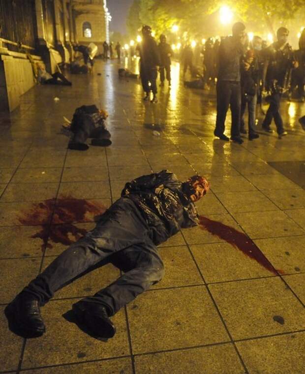 An injured protester lies on the ground after being detained during clashes with police in Tbilisi
